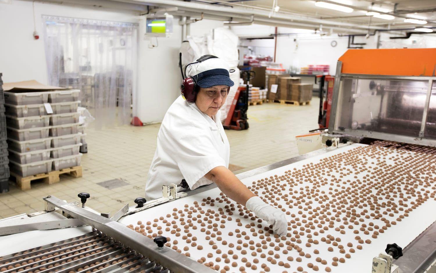 Godis för alla. Mycket av godiset som produceras i Varbergsfabriken säljs i annat namn. ”Vårt godis finns i princip i alla butiker i hela Sverige, även om det inte alltid är vår etikett på förpackningen”, säger Lennart Arvidsson, marknadschef på företaget. Vid en av förpackningslinjerna förbereder Maria Rodrigez punschpraliner innan de får chokladöverdrag med strössel.