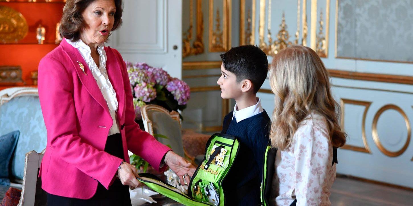 Drottning Silvia köpte årets första majblommor av Alice Ehrén och Youssef Jawady, från Barkarbyskolan, vid en ceremoni på slottet.