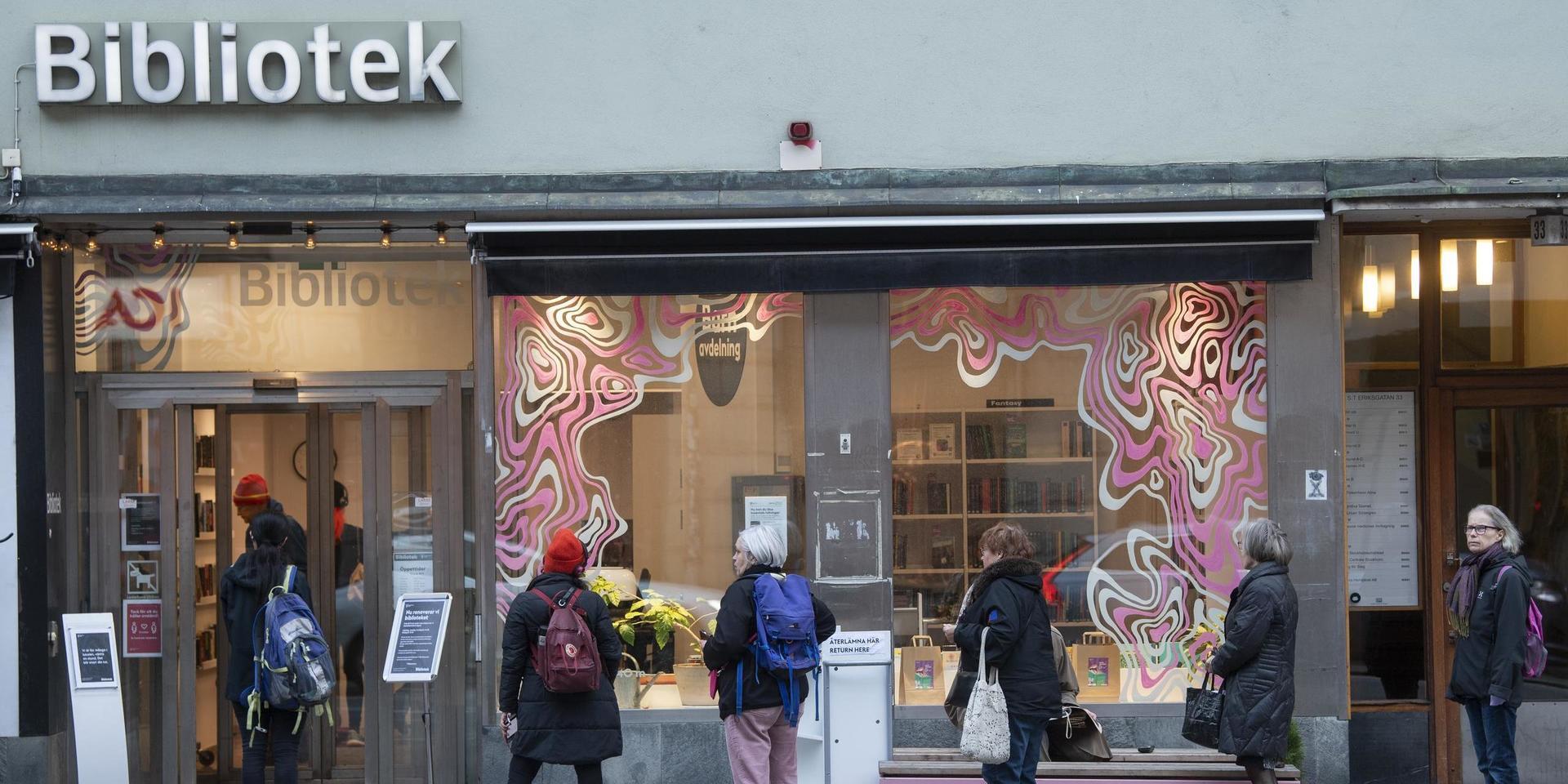 Kö till ett bibliotek i Stockholm när nya coronarestriktioner gör biblioteksbesöken begränsade.